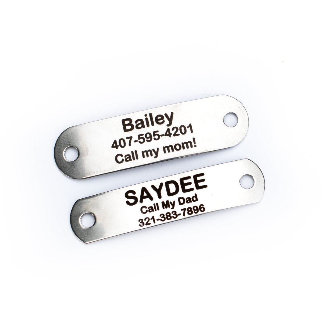 Two metallic tags with engraved names and phone numbers on a white background