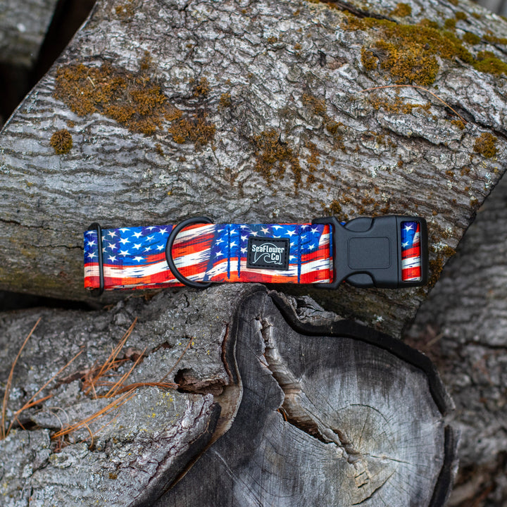 Dog collar with American flag design on a stack of wooden logs